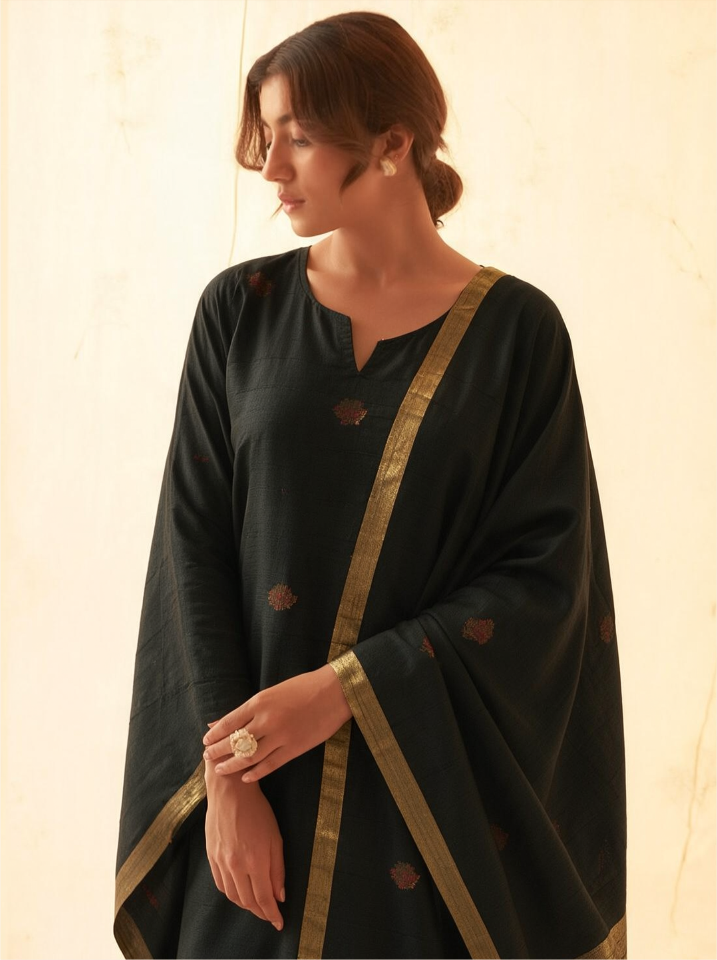 Woman modeling a charcoal black handwoven Matka silk kurta adorned with red meena bootis, styled with a draped dupatta featuring an antique gold tissue border