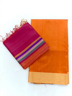 Neatly folded orange raw silk fabric featuring a gold tissue border paired with a folded magenta dupatta displaying vibrant multi-color stripes and fringe tassels on a plain background