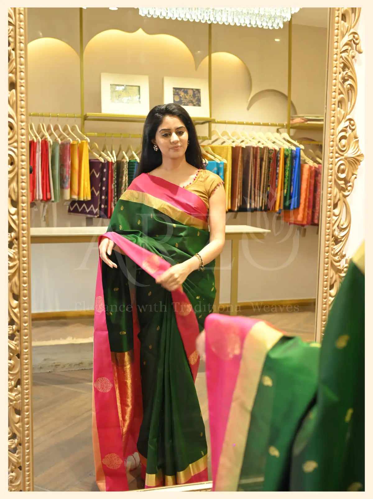 Woman wearing a handwoven dark green Mysore silk saree with a vibrant pink border and gold zari work.