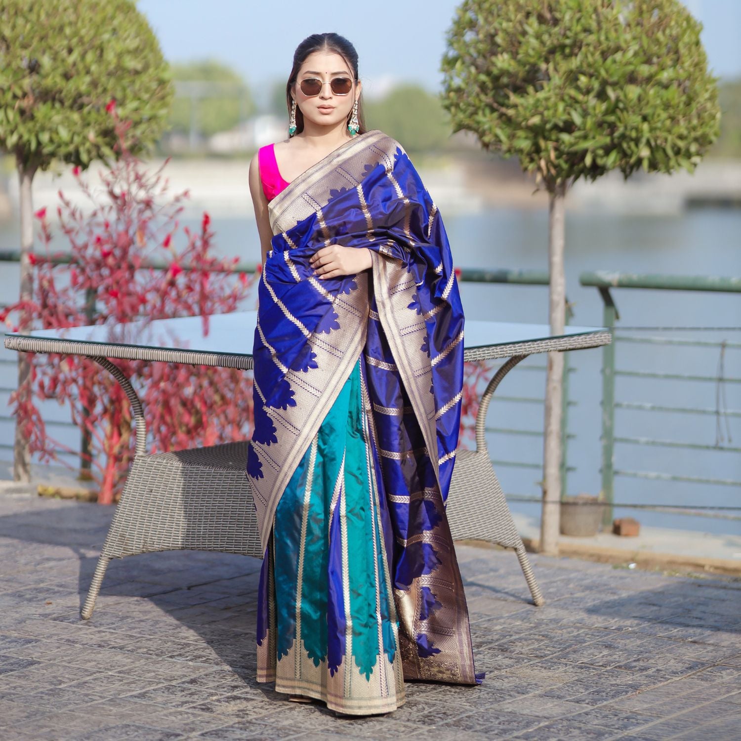 A model wearing a handwoven pure Patola silk saree featuring a traditional woven design in royal blue and pink colors.