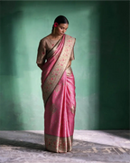 Woman wearing a handwoven pink tissue Patola Kanjivaram silk saree with silver zari border and a beige blouse.