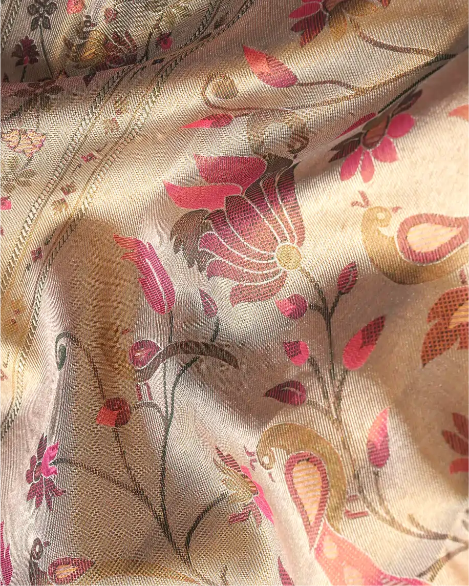 Close-up shot of handwoven pink tissue Patola Kanjivaram silk saree featuring intricate pink floral and peacock motifs woven with zari detailing.