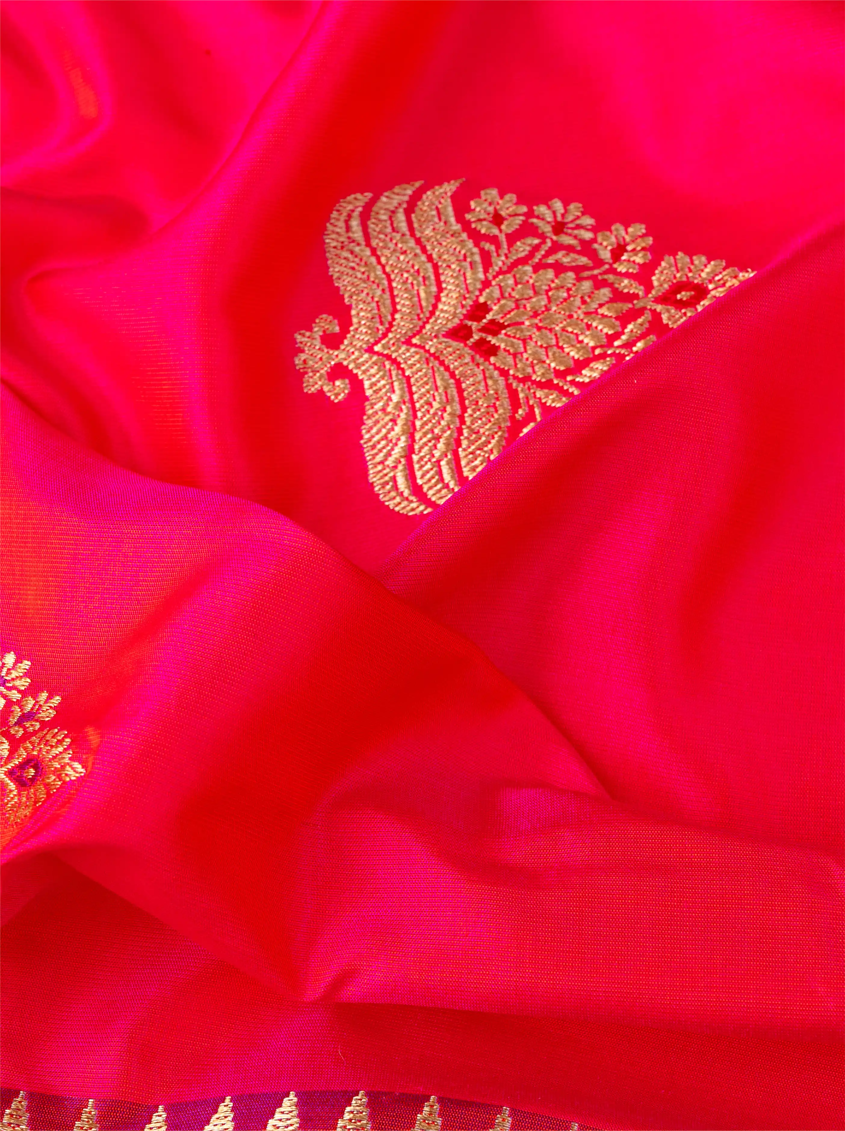 Close-up view of the pallu and border design on a handwoven red pure Katan silk saree showcasing rich gold zari handloom work.