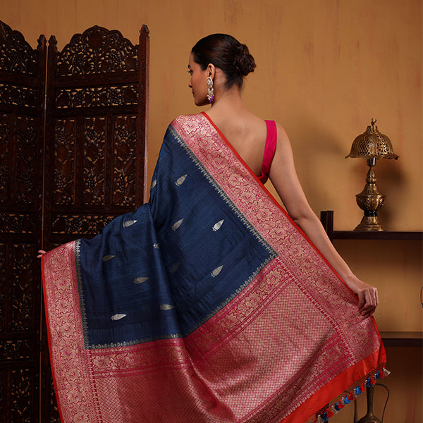 Close-up shot highlighting the intricate handwoven Resham Zari detailing and pink blossom accents on the Midnight Azure georgette fabric