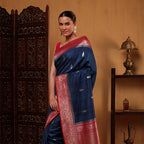 Side profile view of the handwoven Indigo Harmony silk saree showcasing the flowy drape and geometric patterns next to a decorative wooden screen.