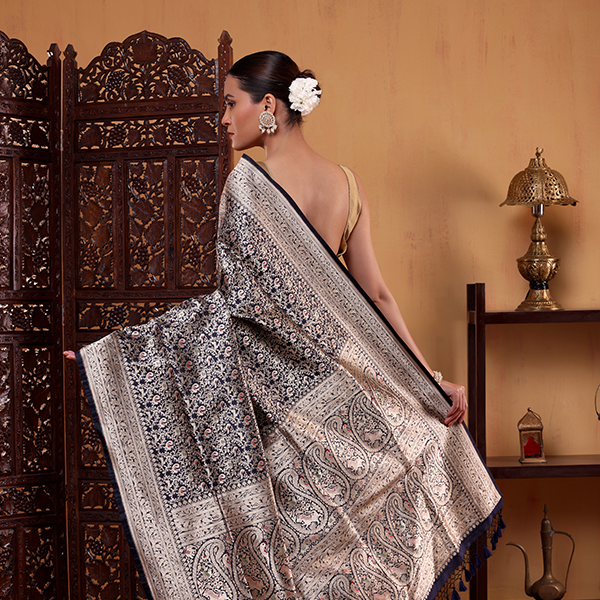 Close-up shot highlighting the premium natural texture and detailed handwoven gold Zari Jaal artwork on the indigo Katan silk fabric.