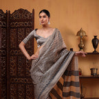 Side profile view of the handwoven Ivory Elegance Tussar silk saree showcasing the full length drape flow and elegant zari border.
