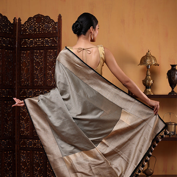 Back view of a woman draping the Ivory Noir Tanchoi Banarasi Silk Saree, showcasing the detailed Resham work and elegant pallu.