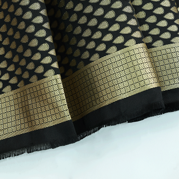 Close-up texture view of the Ivory Noir Tanchoi Banarasi Silk Saree fabric, showcasing the intricate handloom Resham weave and geometric patterns.