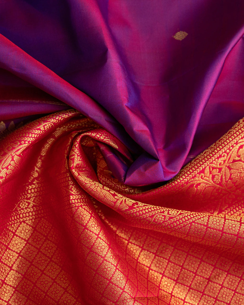 Flat lay photography of the luxurious purple Kanjivaram silk saree with gold border.