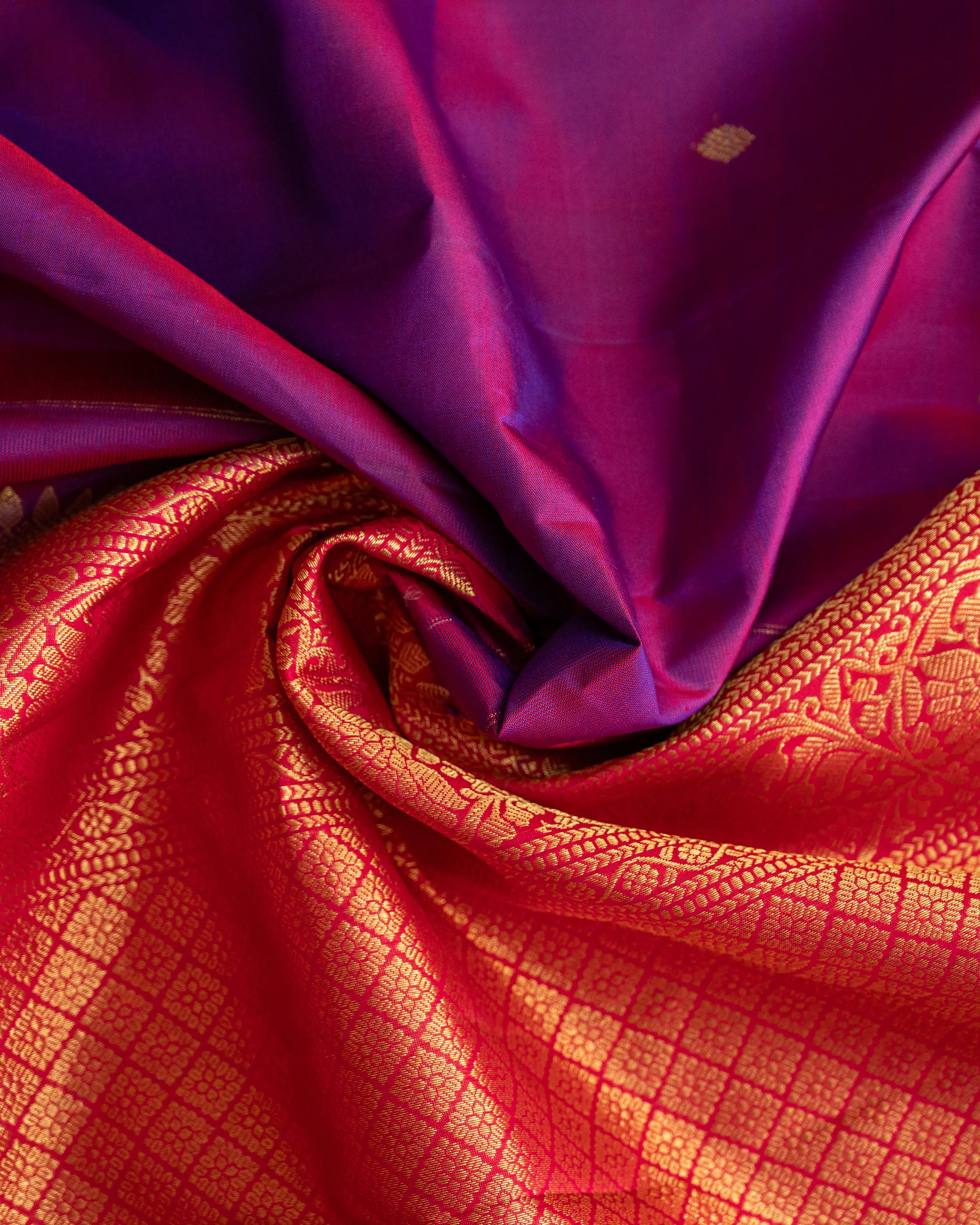 Flat lay photography of the luxurious purple Kanjivaram silk saree with gold border.