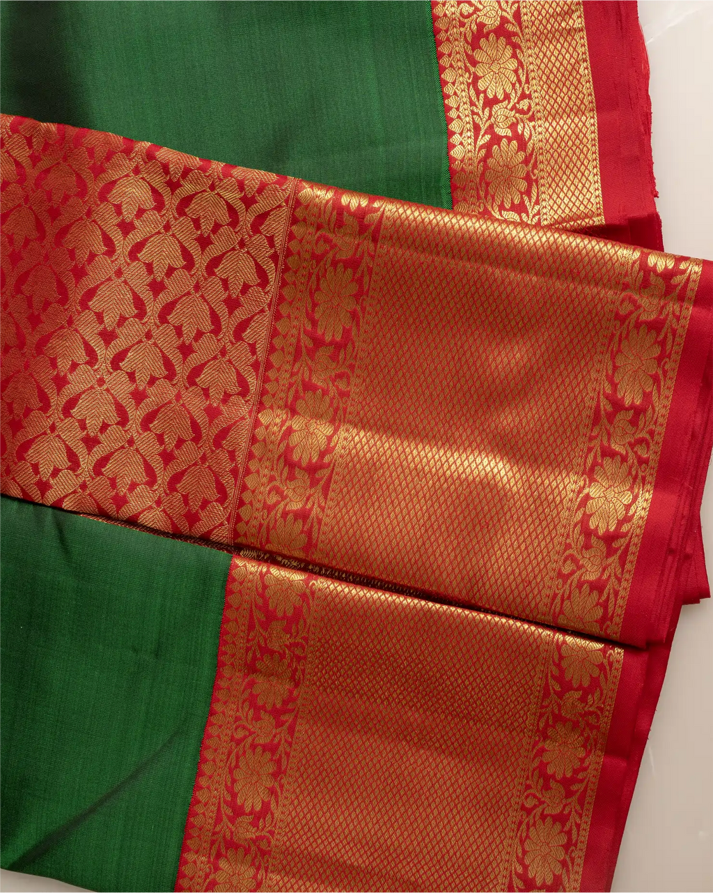 Close-up of the traditional orange silk pallu with intricate gold zari weaving on a Kanjivaram saree.