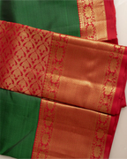 Close-up of the traditional orange silk pallu with intricate gold zari weaving on a Kanjivaram saree.