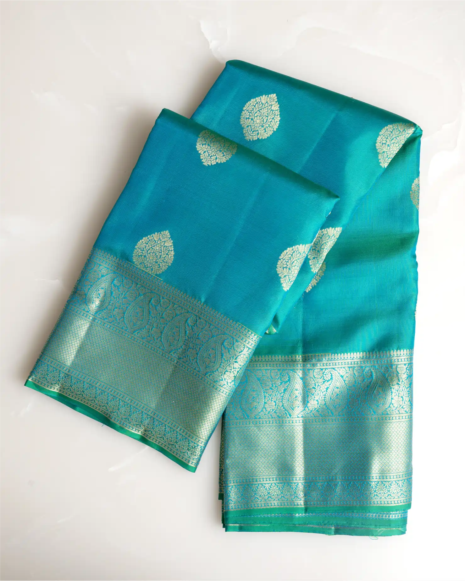 A full-length view showcasing the graceful drape and regal silhouette of the dark teal Kanjivaram saree.