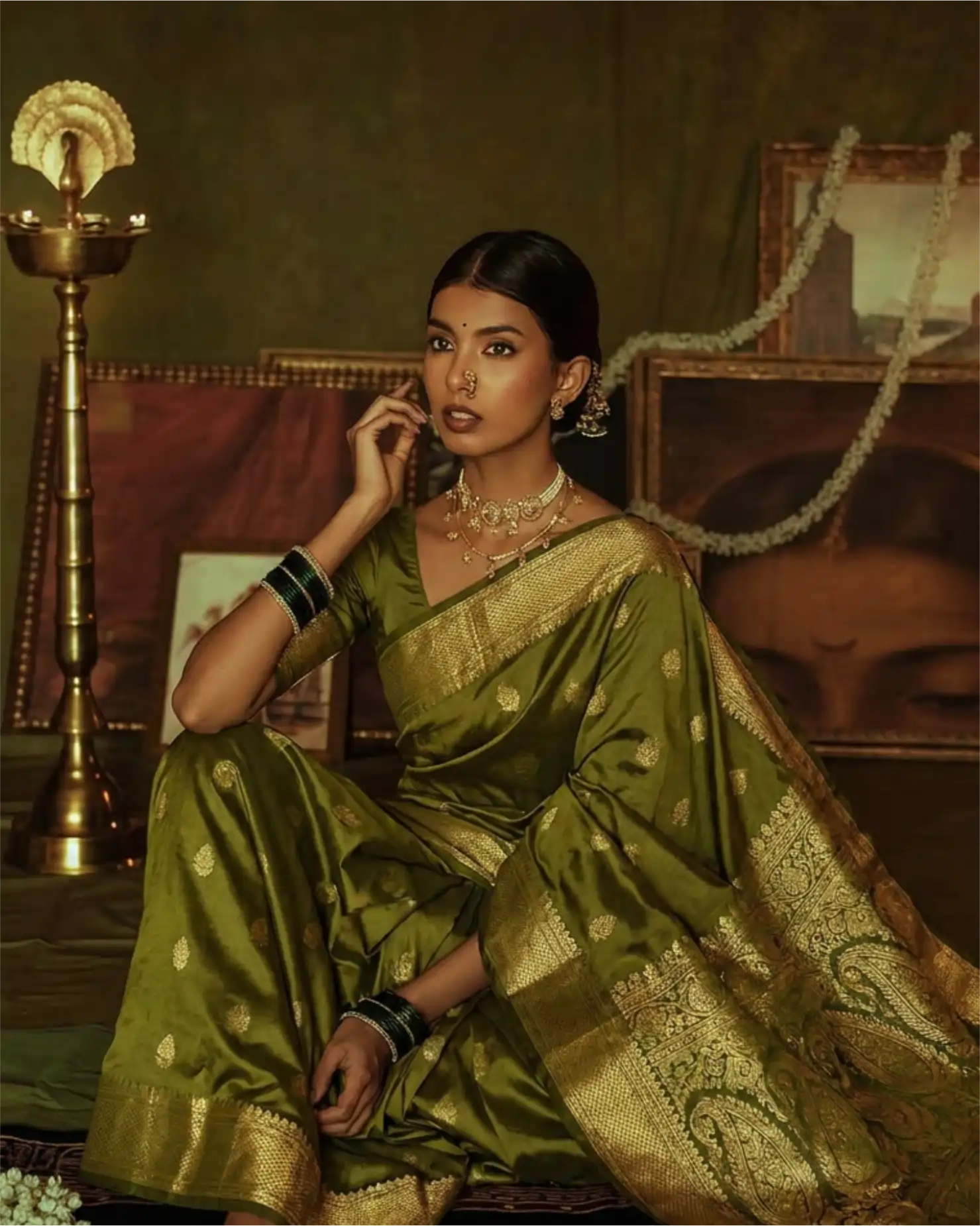 Close-up of the authentic handcrafted gold zari border on an olive green Kanjivaram silk saree.