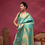 Detailed shot of the opulent heavy gold zari pallu on the Verdant Azure Kanjivaram silk saree, highlighting traditional South Indian handloom weaving.