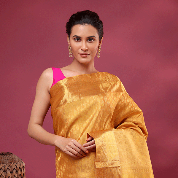 Close-up shot of the handwoven Suchi Kanjivaram silk fabric, showcasing the fine details of the golden mustard resham zari embroidery work.