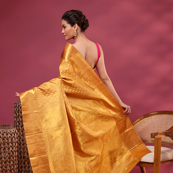 The handwoven self jaal unstitched blouse material with an intricate border, matching the golden mustard Kanjivaram saree.