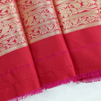 Flat lay or close-up of the unstitched pure red silk blouse fabric featuring a matching gold zari border.