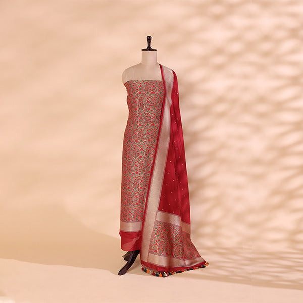 A handwoven Khin Khwab silk suit with a regal garnet base and a luminous cream-spectrum dupatta, featuring intricate Resham and Zari work, displayed on a mannequin.