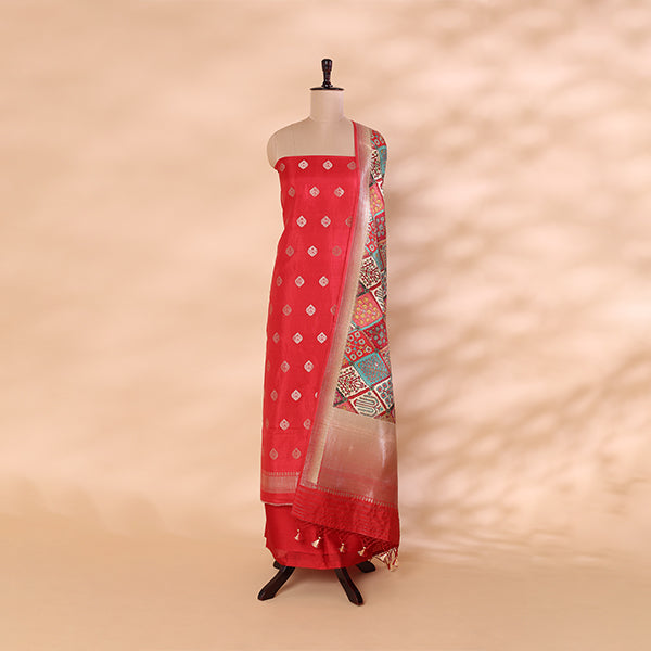 Luminous carrot red pure Banarasi Khadua silk unstitched suit paired with a multicolored, intricately detailed traditional Pichwai dupatta, displayed on a mannequin.