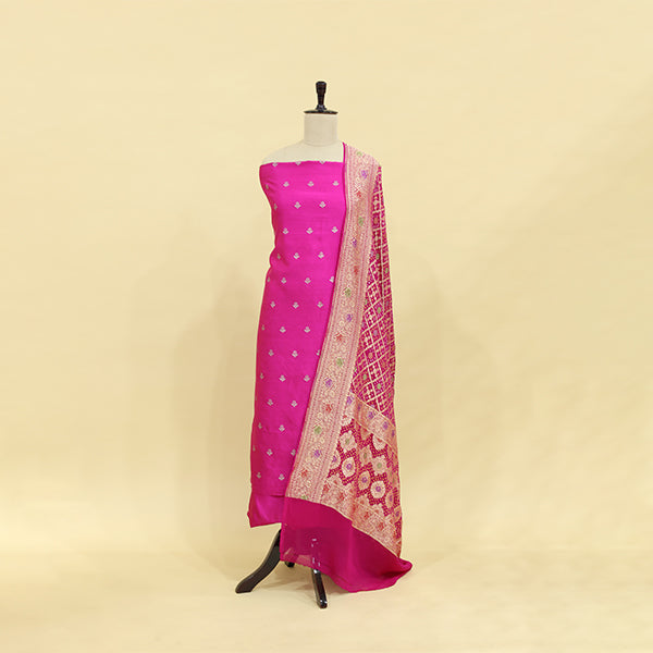 Vibrant magenta pure Banarasi silk suit paired with a fiery sunset red and gold Bandhani dupatta, displayed elegantly on a mannequin.