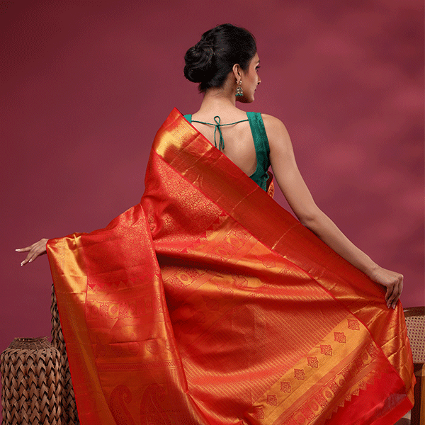 Close-up detail of the heavy, opulent gold zari weaving and intricate traditional motifs on the majestic magenta Kanjivaram silk saree pallu.