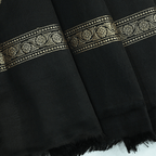 Detailed view of the elegant hanging tassels and heavy gold zari weaving on the pallu of the Midnight Majesty satin silk saree.