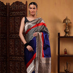 Model wearing the Midnight Majesty blue-black striped Banarasi Satin Silk saree, showcasing the rich drape, red accent pleats, and gold zari border.