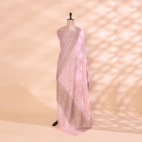Handwoven misty fog-grey Munga Silk suit with an intricate gold Zari border and a vibrant multicolored rainbow tapestry dupatta displayed on a mannequin.