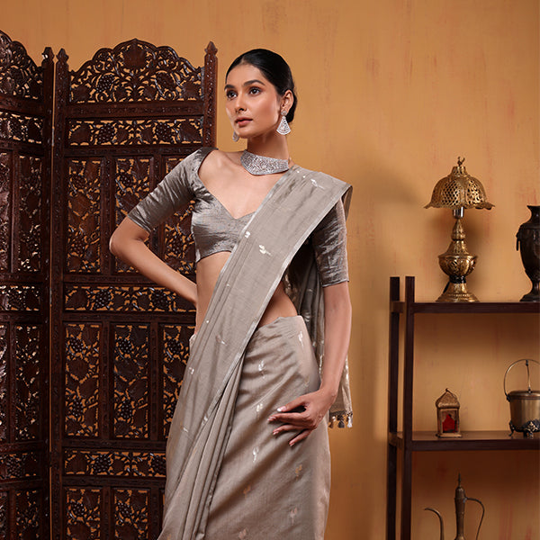 Back view of the model demonstrating the elegant drape and pleat flow of the grey handwoven Banarasi cotton saree.