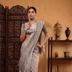 Close-up shot of the fine, delicate hand-woven zari boota motifs distributed across the body of the grey cotton saree.
