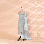 A mannequin displaying a premium moonlit silver Munga silk unstitched suit with an intricate Zari and Resham work neckline, paired with a vibrant multicoloured kaleidoscope horizon dupatta.