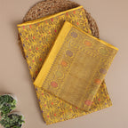 Close-up shot of the intricate traditional Zari and Resham embroidery work on the golden yellow handloom Munga Silk fabric.