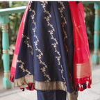Close-up of a Navy Blue Banarasi Silk Kurta featuring intricate gold zari floral embroidery and a red Kora silk dupatta with tassels.