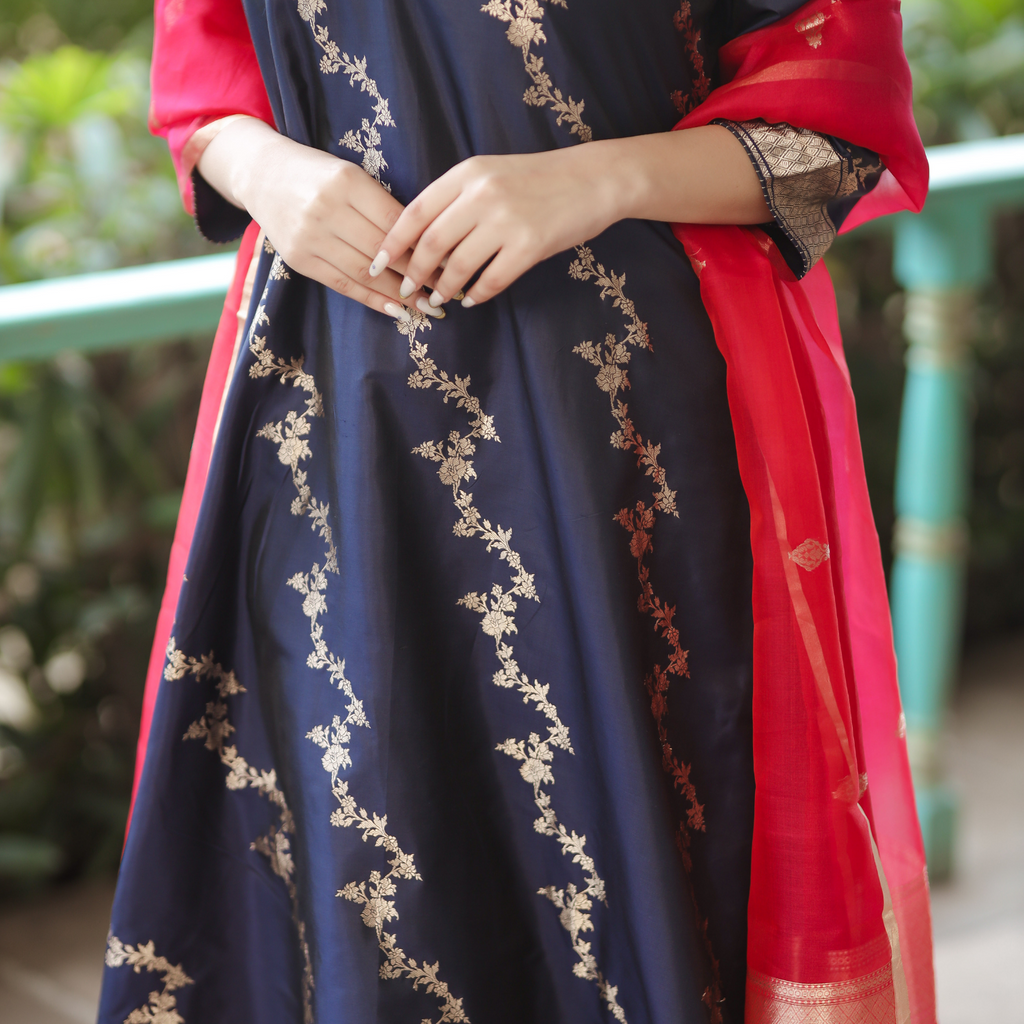 Detailed view of gold zari hand-embroidery on a Navy Blue Banarasi Silk suit featuring floral patterns and a red Kora silk dupatta.