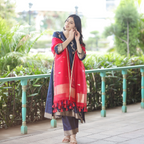 Elegant side profile of a Navy Blue Handwoven Banarasi Silk Suit with gold zari detailing, 3/4 sleeves, and a red Kora silk dupatta.