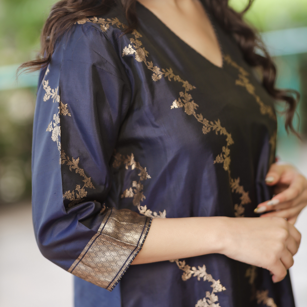 Close-up of the 3/4 sleeve on a Navy Blue Banarasi Silk suit, featuring a thick gold zari border and intricate floral hand-embroidery.