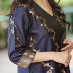 Close-up of the 3/4 sleeve on a Navy Blue Banarasi Silk suit, featuring a thick gold zari border and intricate floral hand-embroidery.