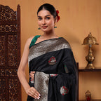 Close-up shot of the heavily woven golden zari pallu and artistic traditional motifs on the ocean blue silk saree.