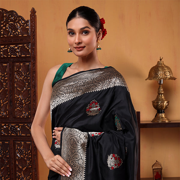 Close-up shot of the heavily woven golden zari pallu and artistic traditional motifs on the ocean blue silk saree.