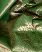 Full-length view of the olive green Kanjivaram silk saree showcasing its graceful drape and silhouette. 