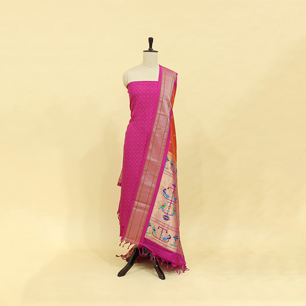 A mannequin displaying an unstitched vibrant orchid pure Banarasi silk suit draped with a regal golden Paithani dupatta.