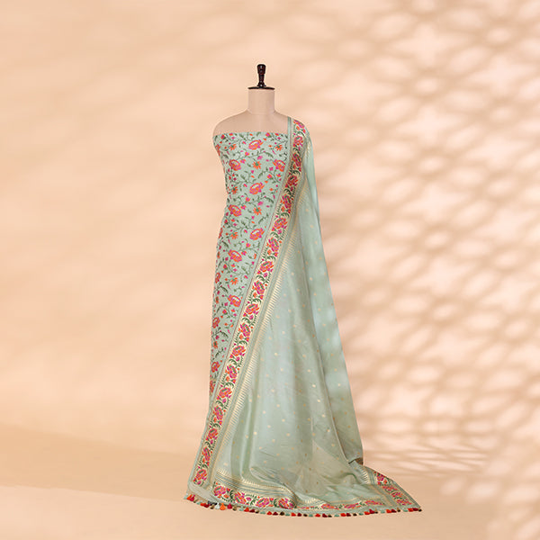 A mannequin showcasing an elegant pastel green handwoven silk suit, featuring delicate floral patterns, intricate zari borders, and a matching dupatta