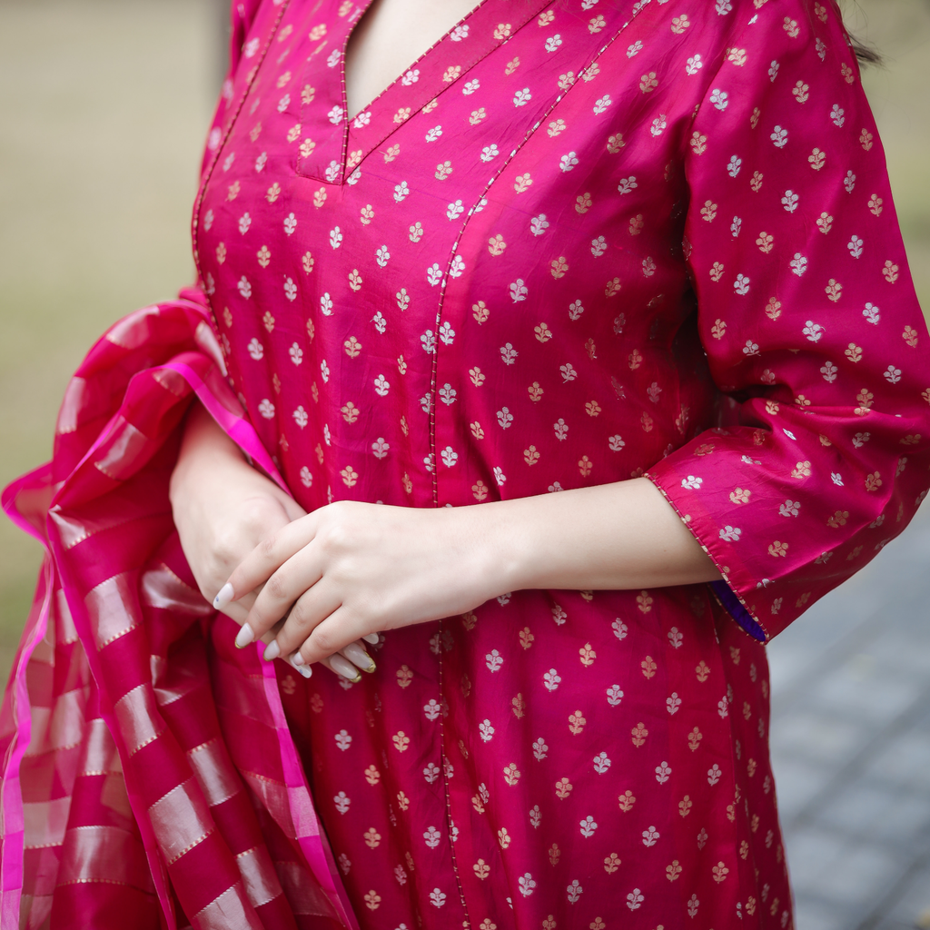 Detailed close-up of the pink handloomed Banarasi silk fabric featuring gold and silver Sona Rupa small bootas and intricate floral zari weaving.