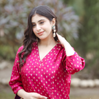 Close-up portrait of a woman in a pink Banarasi silk suit, showcasing the intricate gold and silver Sona Rupa zari motifs and elegant V-neck design.