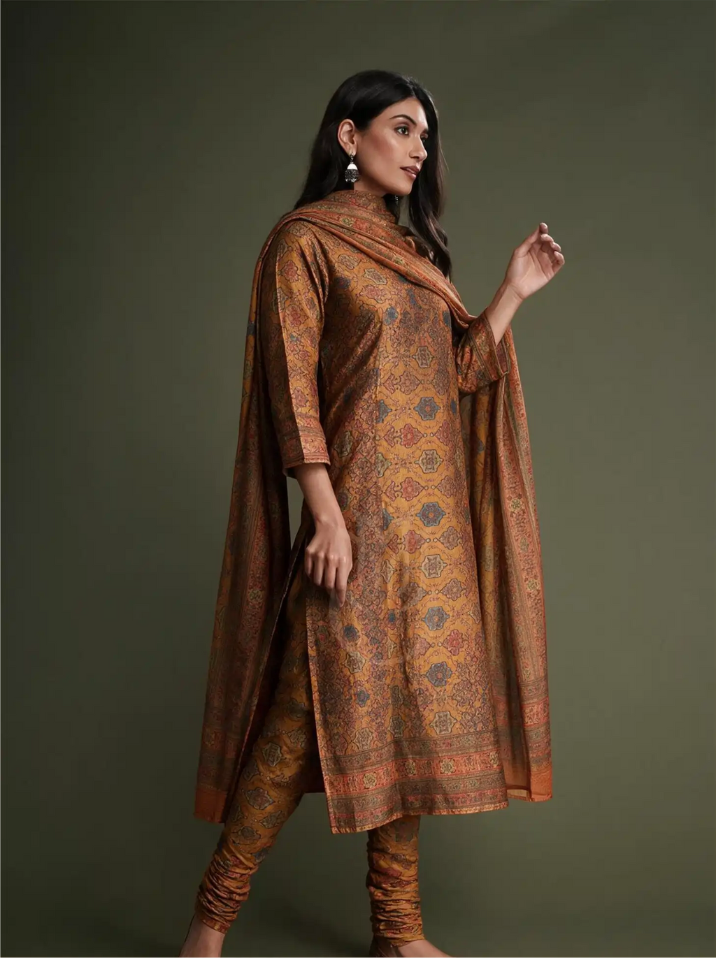 Model posing in Pure Boski Silk Mustard Yellow Suit Set with slate blue geometric floral print, fitted churidar, and matching draped dupatta against a studio backdrop