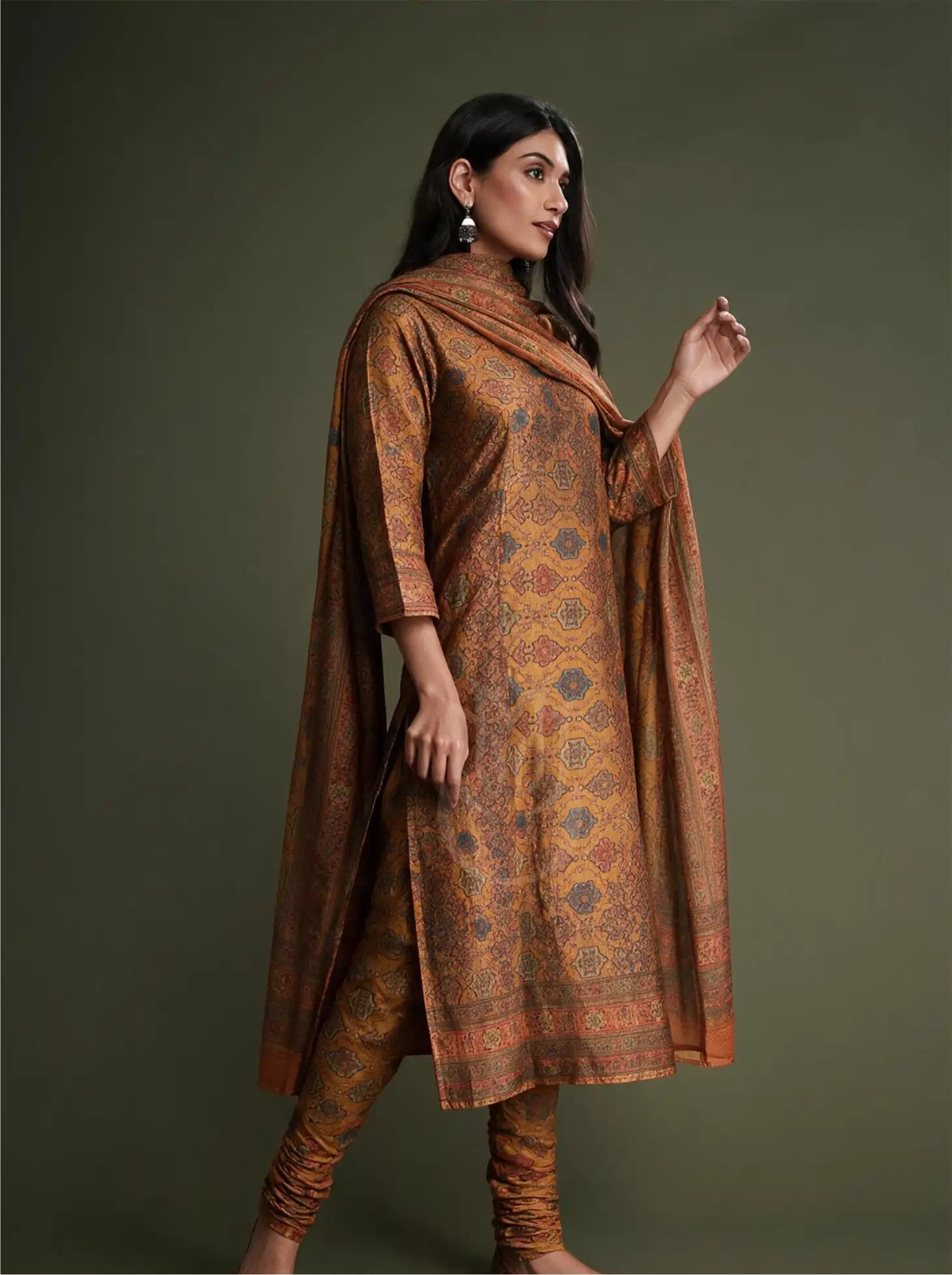 Model posing in Pure Boski Silk Mustard Yellow Suit Set with slate blue geometric floral print, fitted churidar, and matching draped dupatta against a studio backdrop