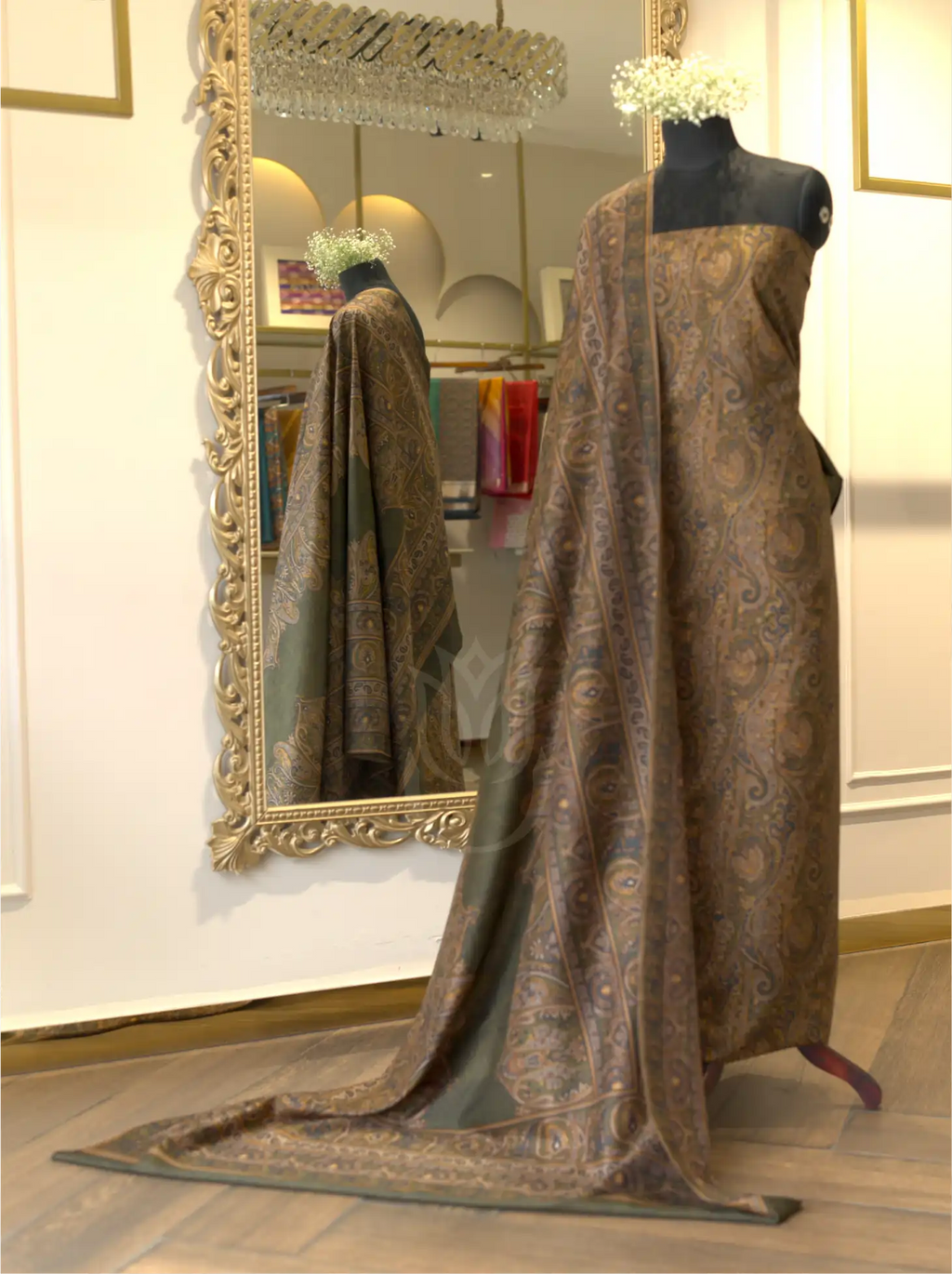Folded olive green pure Boski silk suit fabric close-up highlighting textured geometric weave and printed Kashmiri paisley border