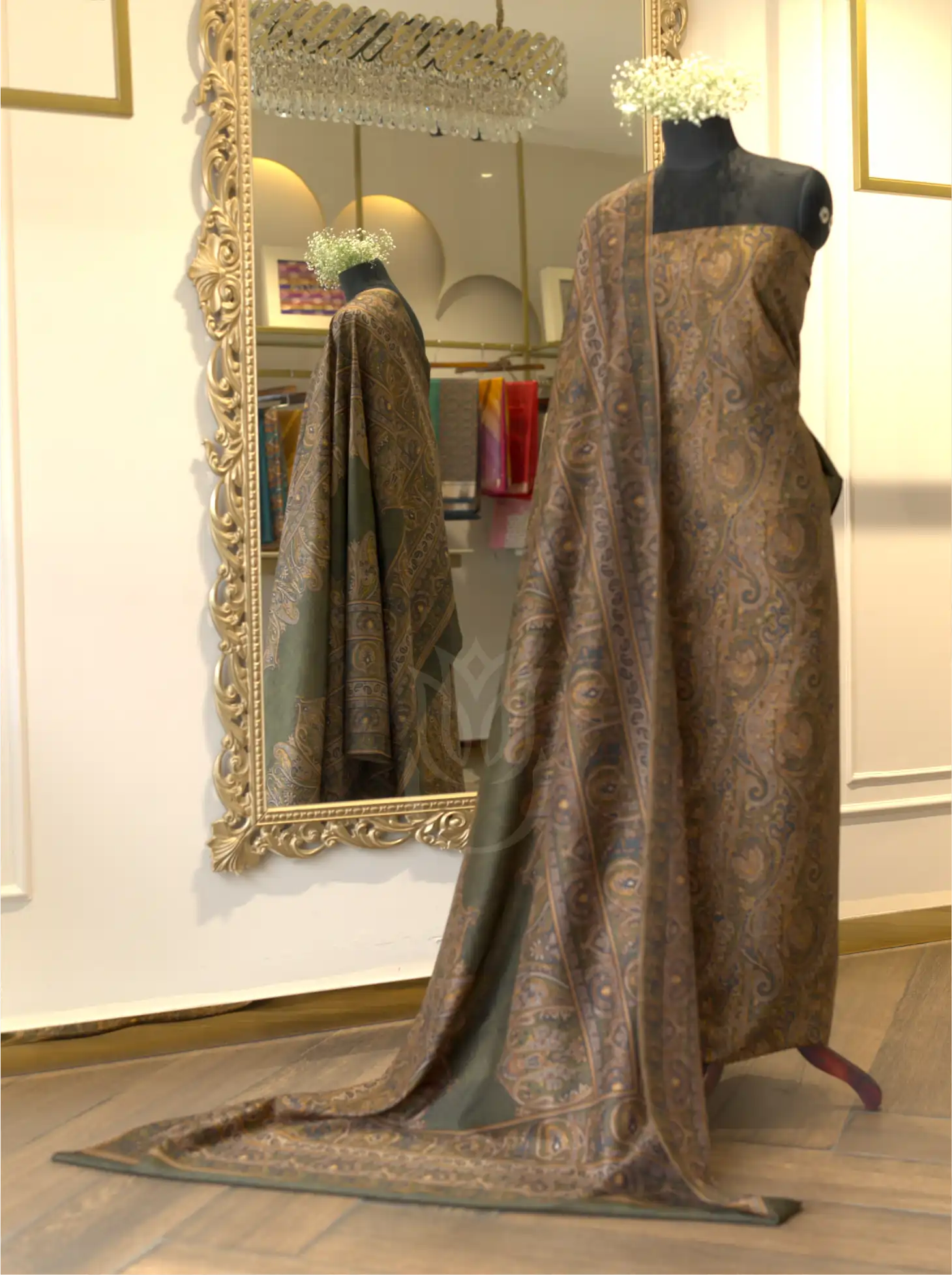 Folded olive green pure Boski silk suit fabric close-up highlighting textured geometric weave and printed Kashmiri paisley border